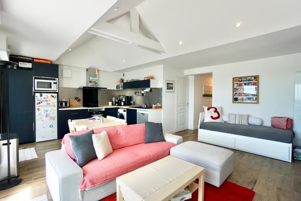 un salon avec un canapé rouge et une cuisine dans l'établissement Ollie Blue-50m de la plage, à Ploemeur