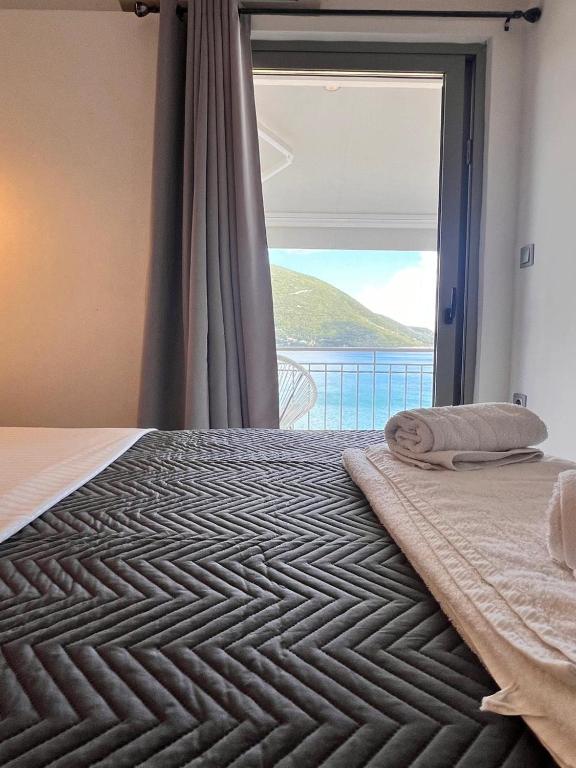 a bedroom with a bed with a large window at Ponti Bay Apartments in Vasiliki