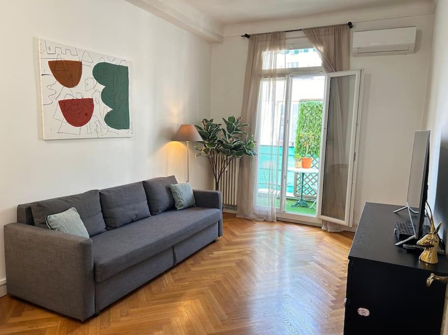 un salon avec un canapé et une télévision dans l'établissement Appartement 4 chambres face Gare Nice-ville, à Nice