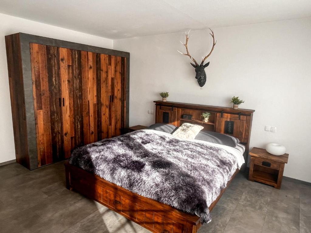 a bedroom with a bed and a deer head on the wall at Landhaus Stetten in Stetten