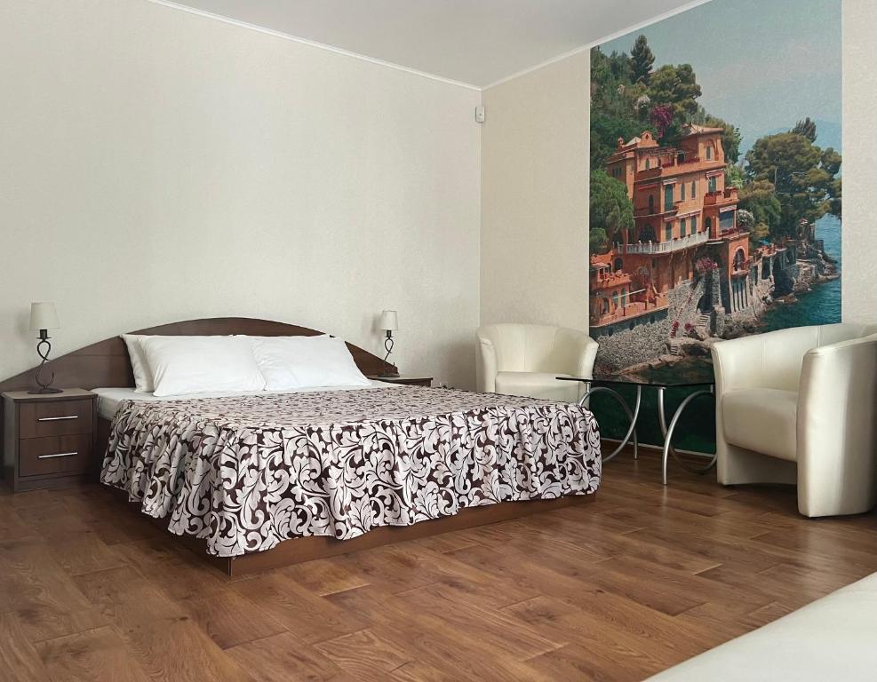 een slaapkamer met een bed en een schilderij aan de muur bij Apart hotel Asotel in Charkov