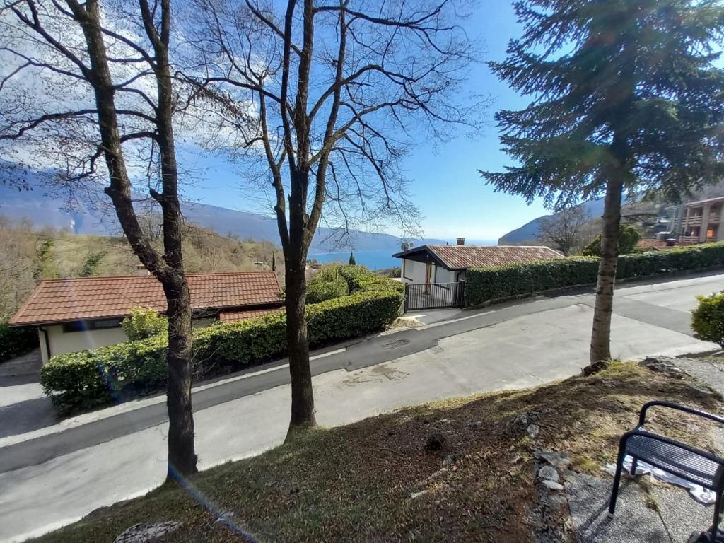 a bench sitting on the side of a road with trees at La Bella Garda in Tignale