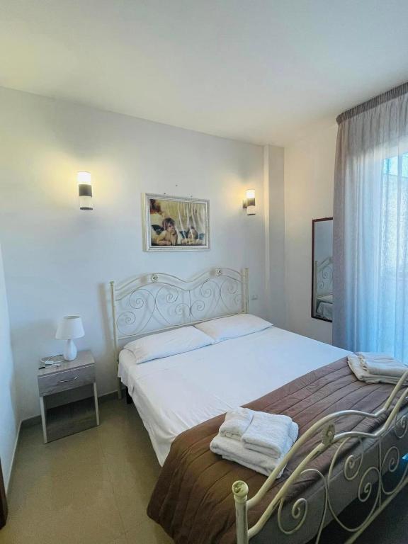 a bedroom with a large white bed and a window at La casa di Chloé in Alezio