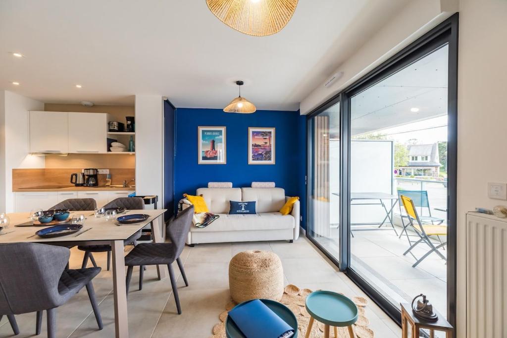 a living room with a blue accent wall at Les terrasses de Ploumanac'h 150m de la plage in Perros-Guirec