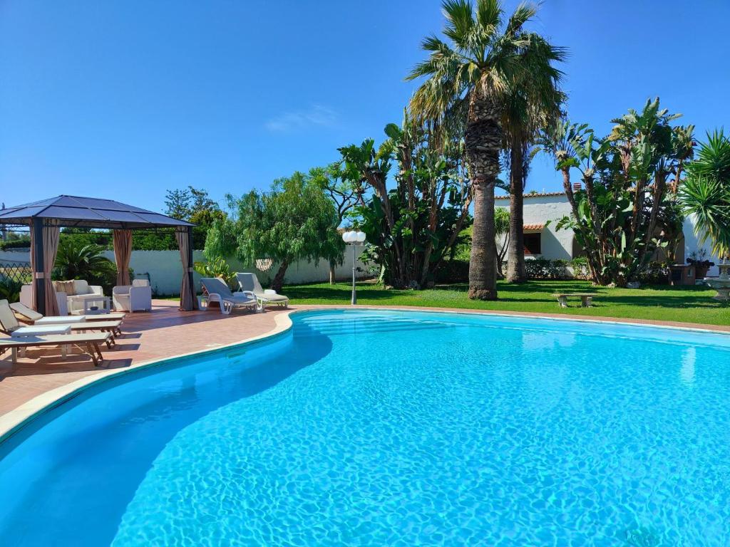 uma piscina com cadeiras e um gazebo em Villa Alfonsa, Fontane Bianche, Siracusa, PRIVATE POOL, 10min from the beach em Fontane Bianche