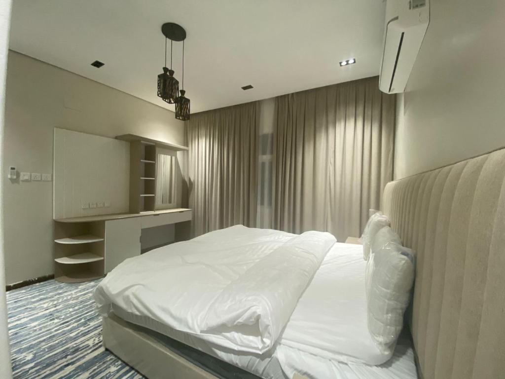 a bedroom with a large white bed in a room at درة العزيزية للشقق المفروشة in AlUla