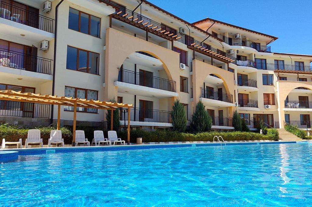 a hotel with a swimming pool in front of a building at Arkite - Private apartment - BSR in Sunny Beach