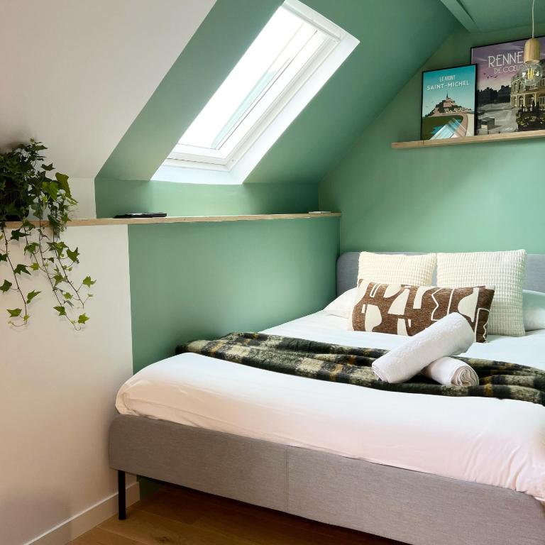 - une chambre avec un lit et une lucarne dans l'établissement Le Verdun, Centre de Rennes, à Rennes