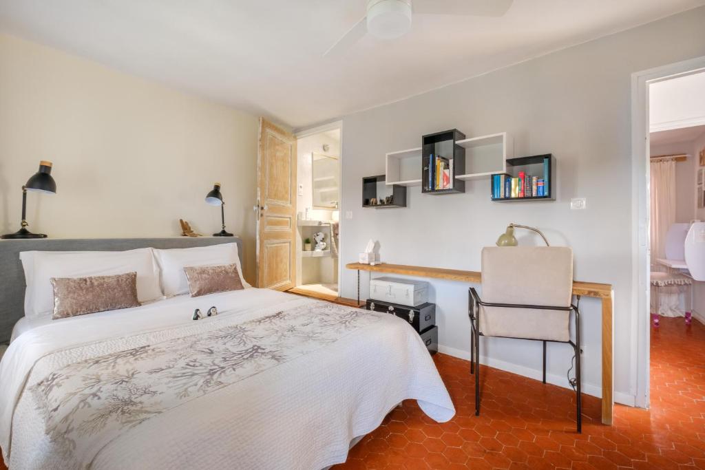 a bedroom with a white bed and a desk at Maison de village romantique in Cagnes-sur-Mer