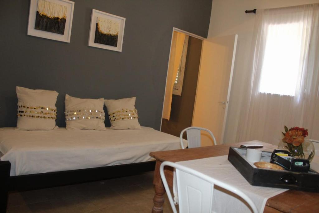 una camera da letto con un letto, un tavolo e uno specchio di APART-HOTEL Qh a Bella Vista