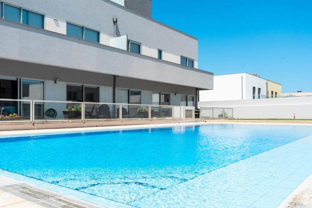 a swimming pool in front of a building at Oporto city and Beach apartment in Lavra