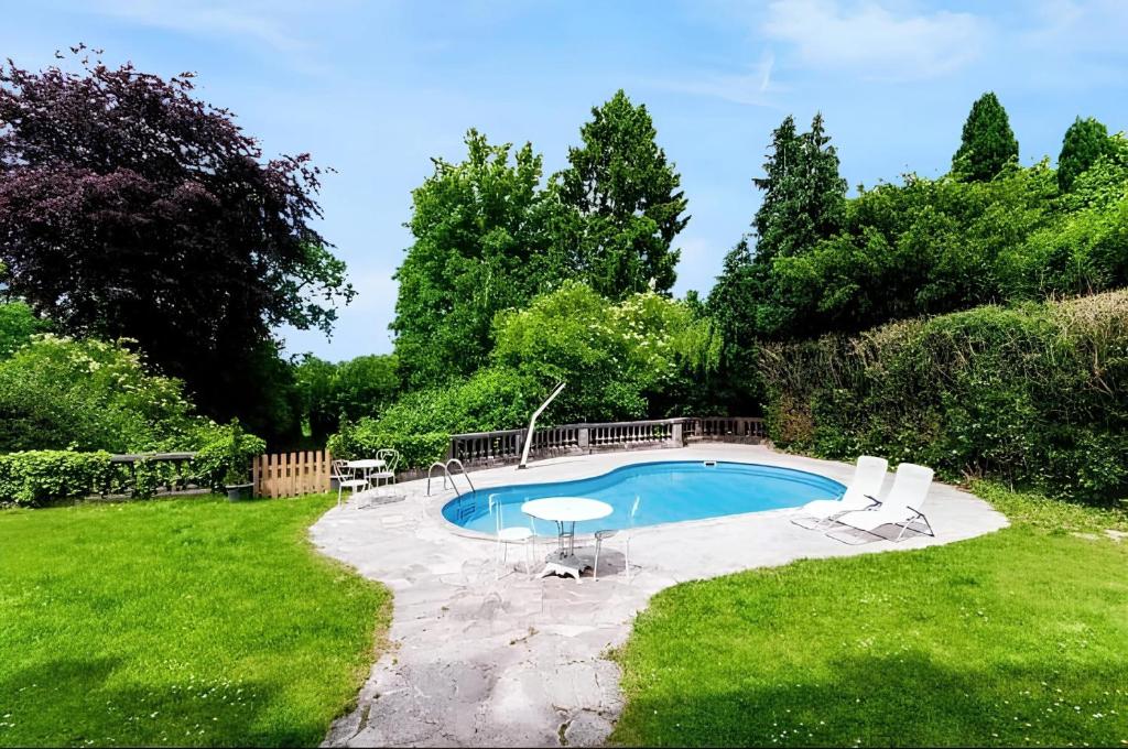 una piscina en un patio con 2 sillas y una mesa en Maison de 5 chambres avec piscine privee jardin clos et wifi a Bailleul, en Bailleul