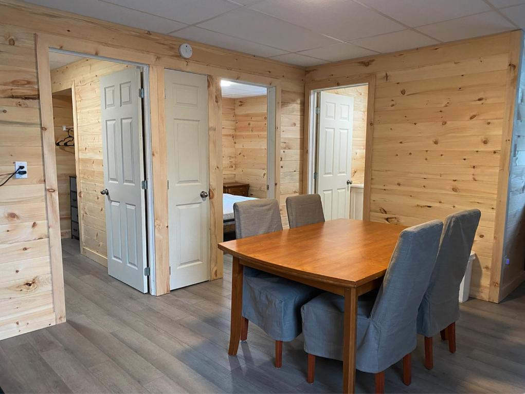 a dining room with a wooden table and chairs at Camping Gaulois - Chalet Vert in Scott
