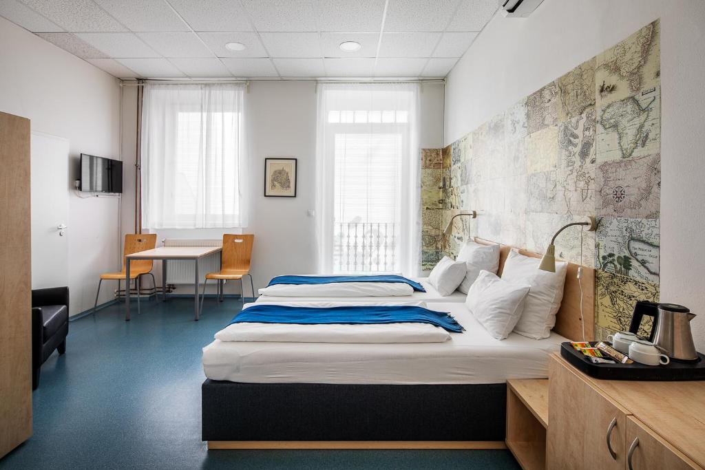 a hotel room with two beds and a desk at Hostel Florenc in Prague