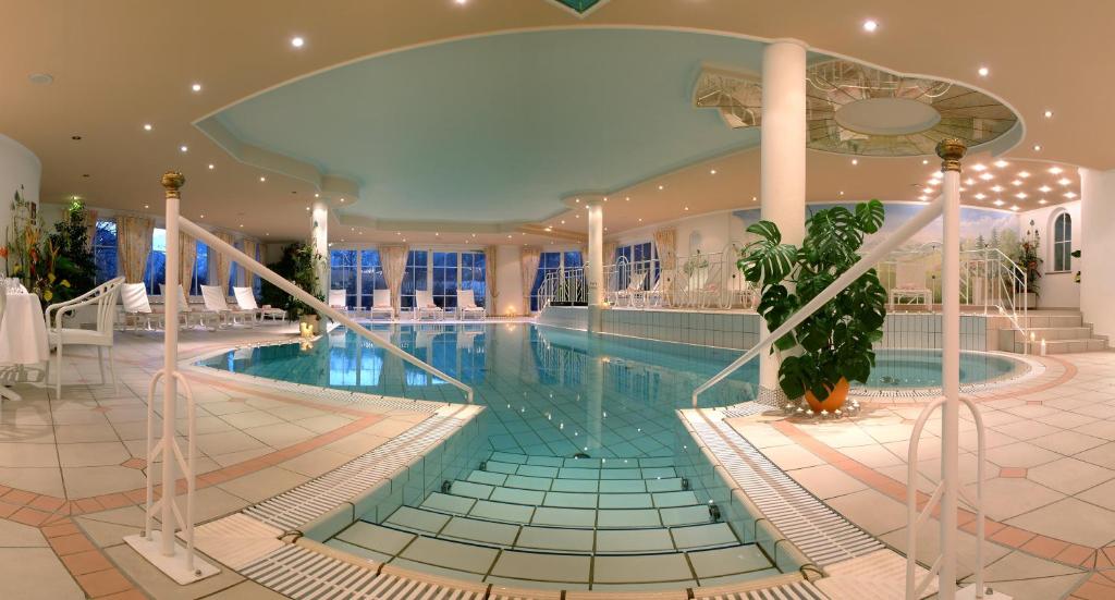 a large swimming pool in a large building with a pool at Hotel Zum Stern in Bad Hofgastein