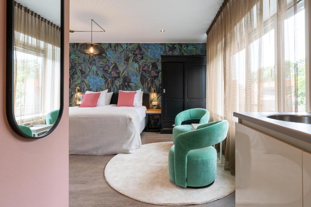 a bedroom with a bed and a green chair at Juuls Domburg in Domburg