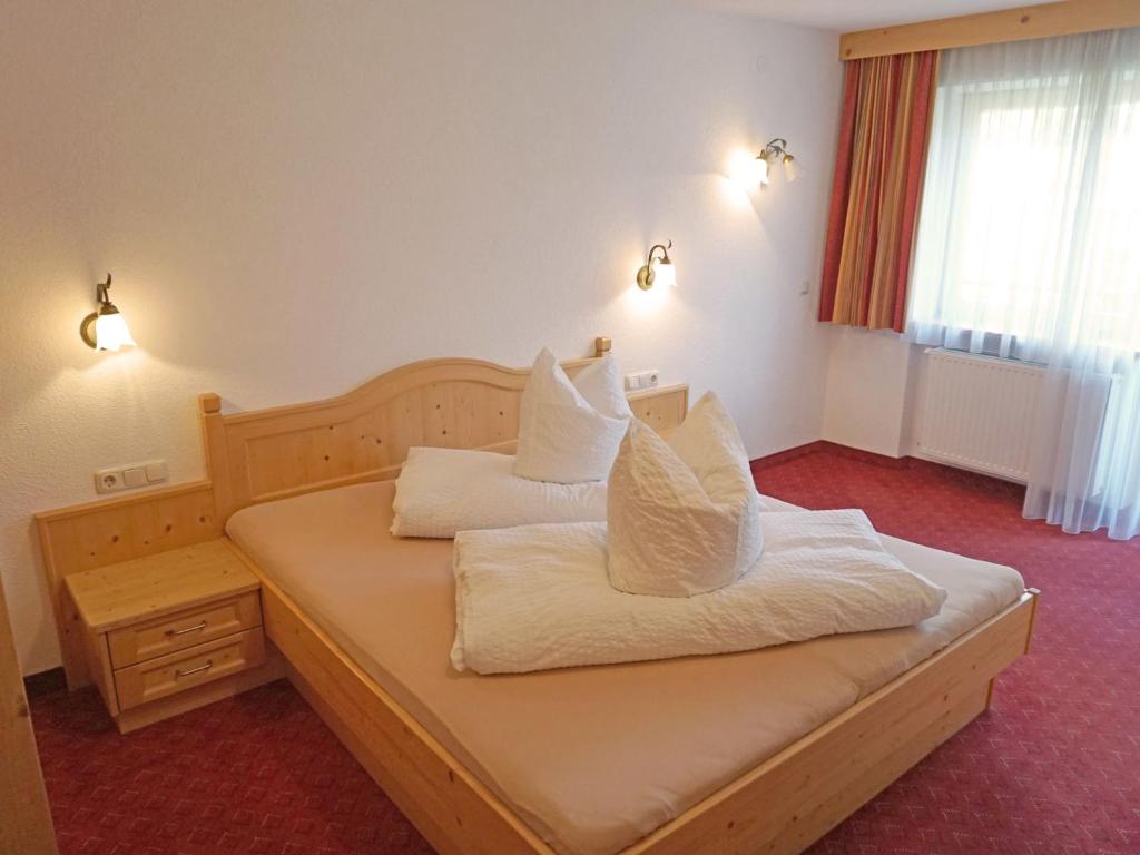 sypialnia z łóżkiem z białą pościelą i poduszkami w obiekcie Apartment Diana-3 by Interhome w mieście Pettneu am Arlberg