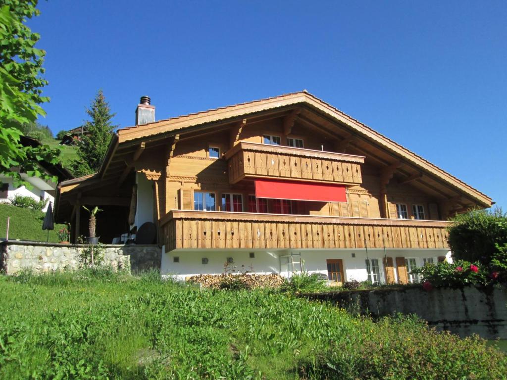 ein großes Holzhaus auf einem Hügel in der Unterkunft Apartment Isabelle by Interhome in Lenk im Simmental
