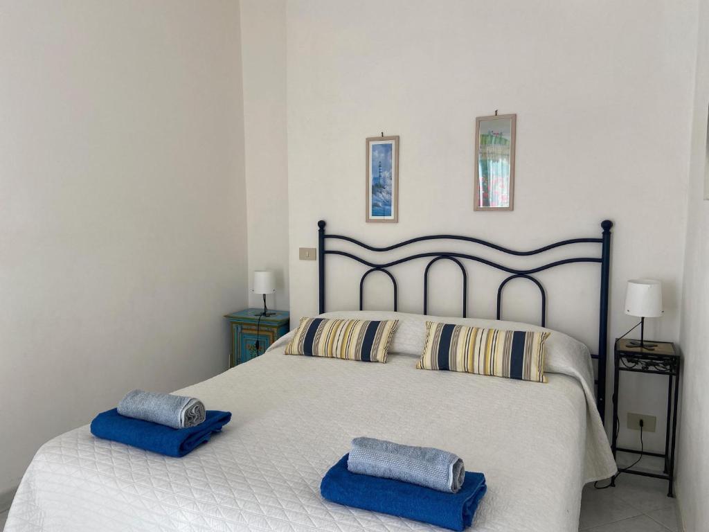 a bedroom with a bed with two blue pillows on it at Rosa Dei Venti Marettimo in Marettimo