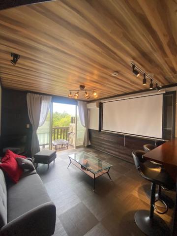 a living room with a couch and a screen at VILLENT シエロ伊豆宇佐美 in Ito