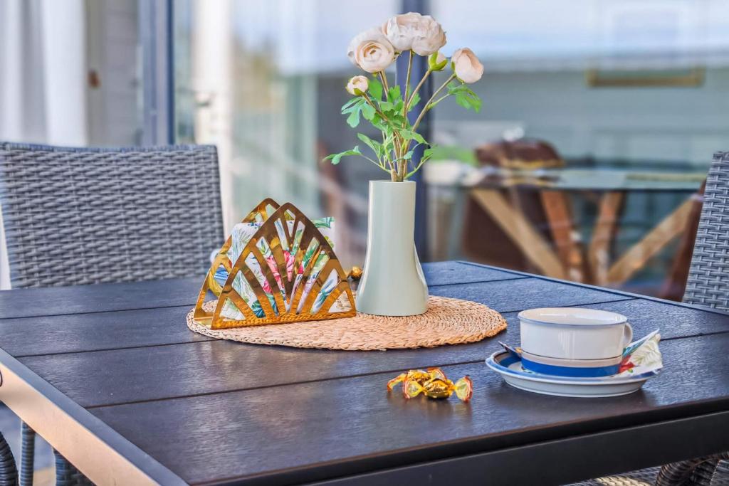 een tafel met een vaas met bloemen en een hoed bij Merikruunu tähdistöhuvila Otava 15 in Dragsfjärd