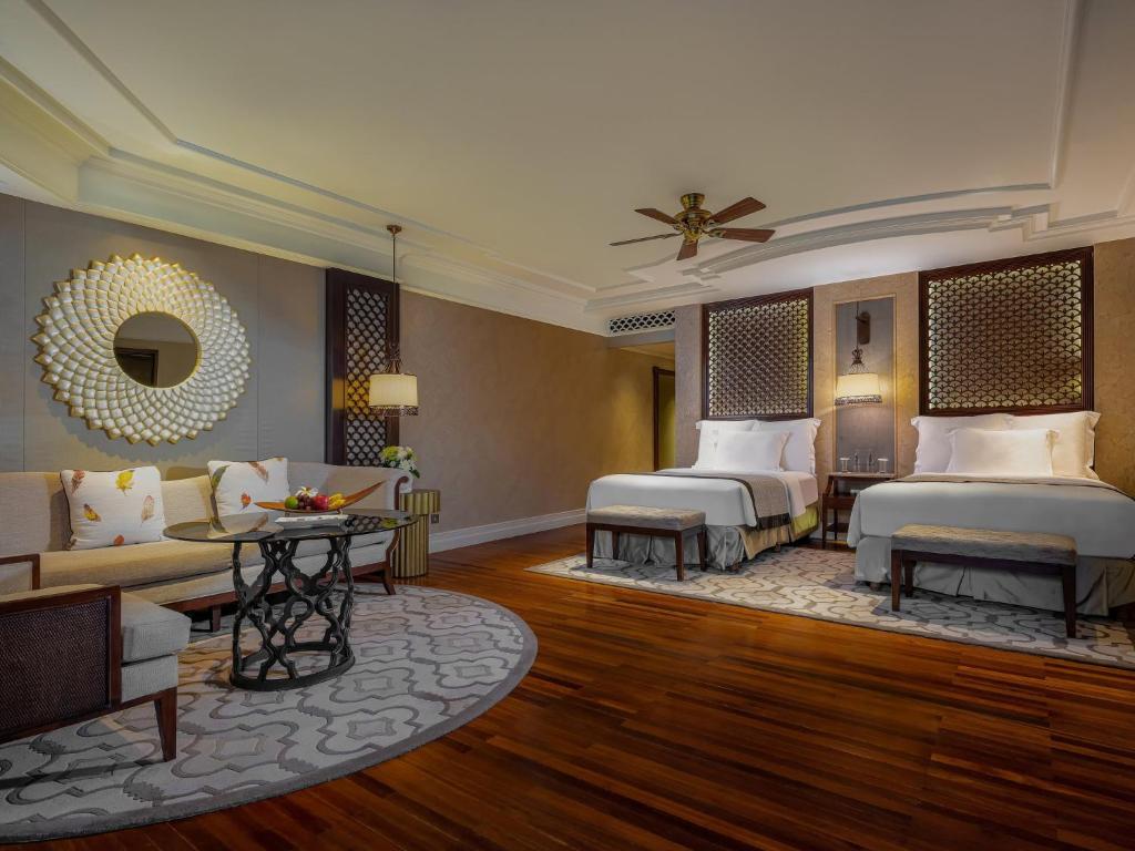 a hotel room with two beds and a couch at InterContinental Bali Resort by IHG in Jimbaran
