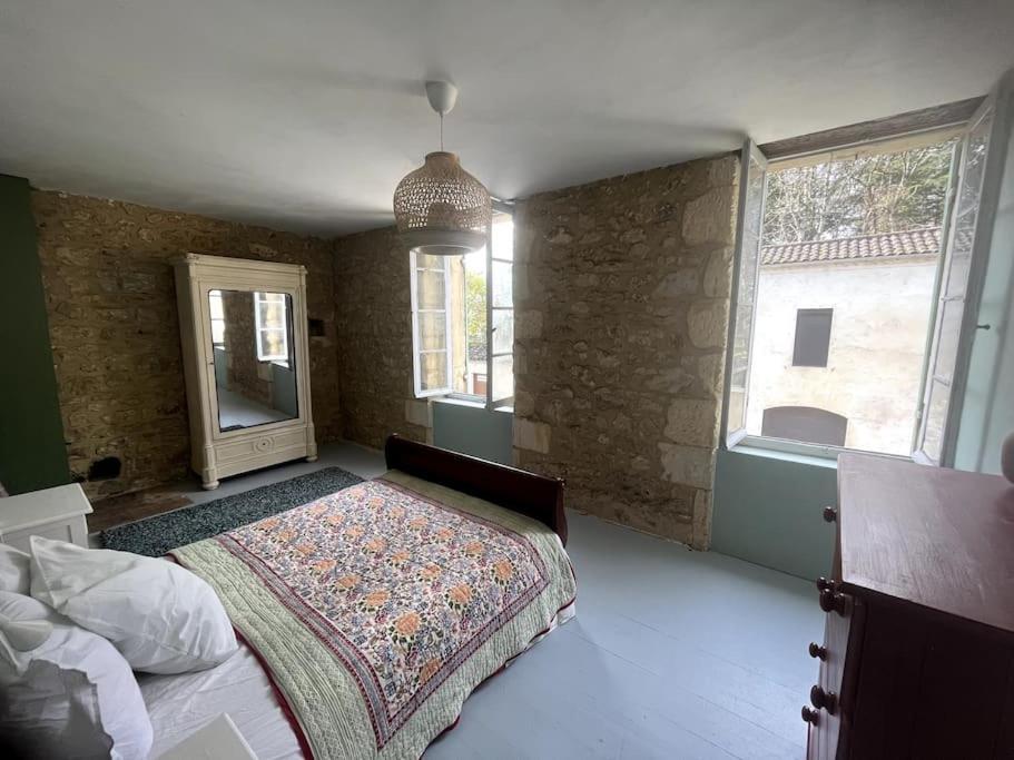 une chambre avec un lit et une grande fenêtre dans l'établissement Cozy town centre cottage, à Beaumont-du-Périgord