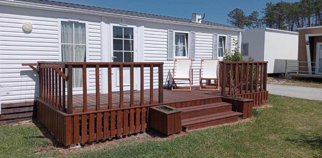 a large wooden deck in front of a house at Bungalow au bord de la piscine 4 pers 5A in Burinhosa