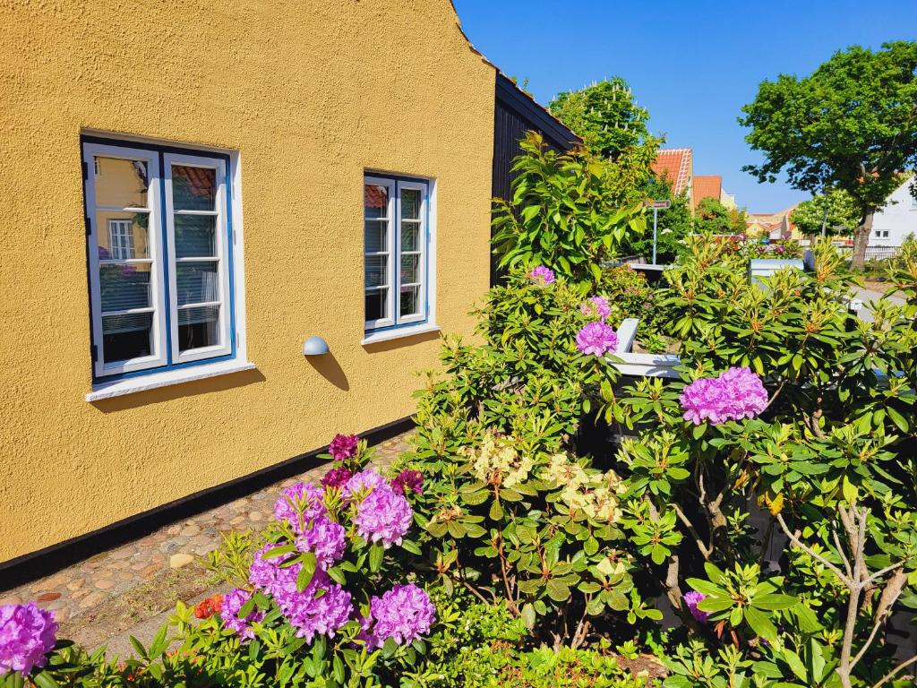 una casa amarilla con flores delante en Tinghus Flat en Skagen