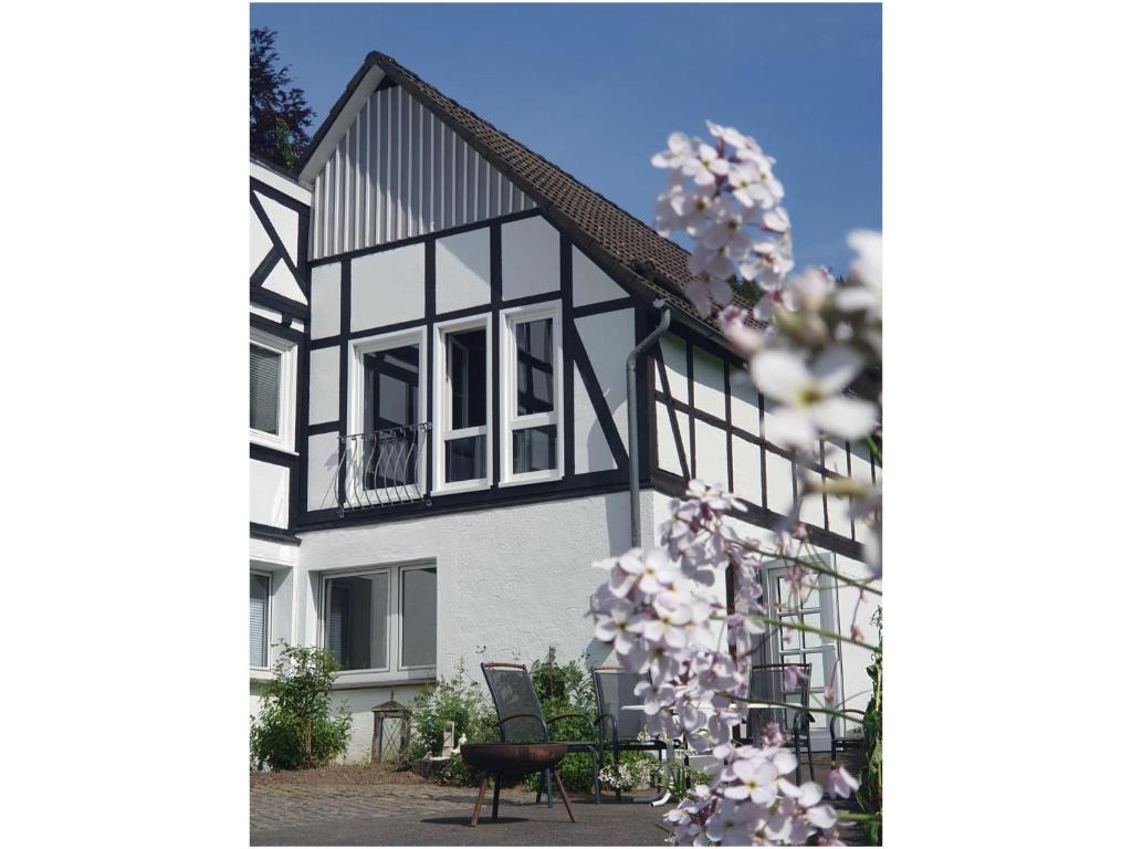 een huis met een bloeiende boom ervoor bij Paradiesken am Berg in Schmallenberg