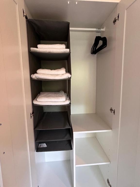 a walk in closet with white shelves and towels at Stilvolles Apartment am ICE Bahnhof in Kassel