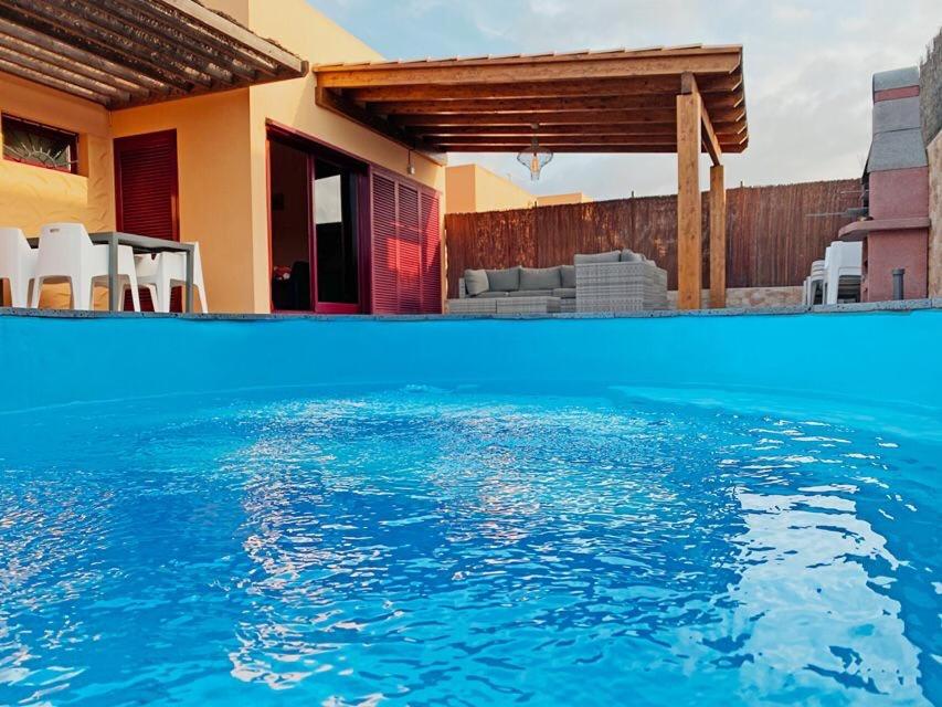 a swimming pool in front of a house at CASA JAMACO, Corralejo in Corralejo