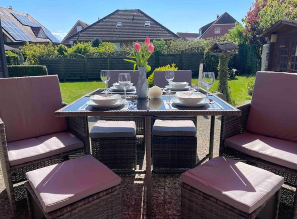 a table with chairs and wine glasses on a patio at Ankerplatz - gemütliches Ferienhaus mit Garten und Terrasse für die große Familie in Grömitz