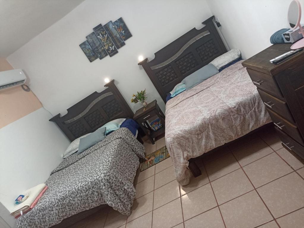 een slaapkamer met 2 bedden en een dressoir bij Casa Chero in Comalcalco