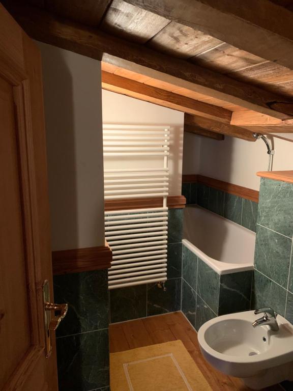 uma casa de banho com um lavatório e uma banheira em Chesa Cotschna em Celerina