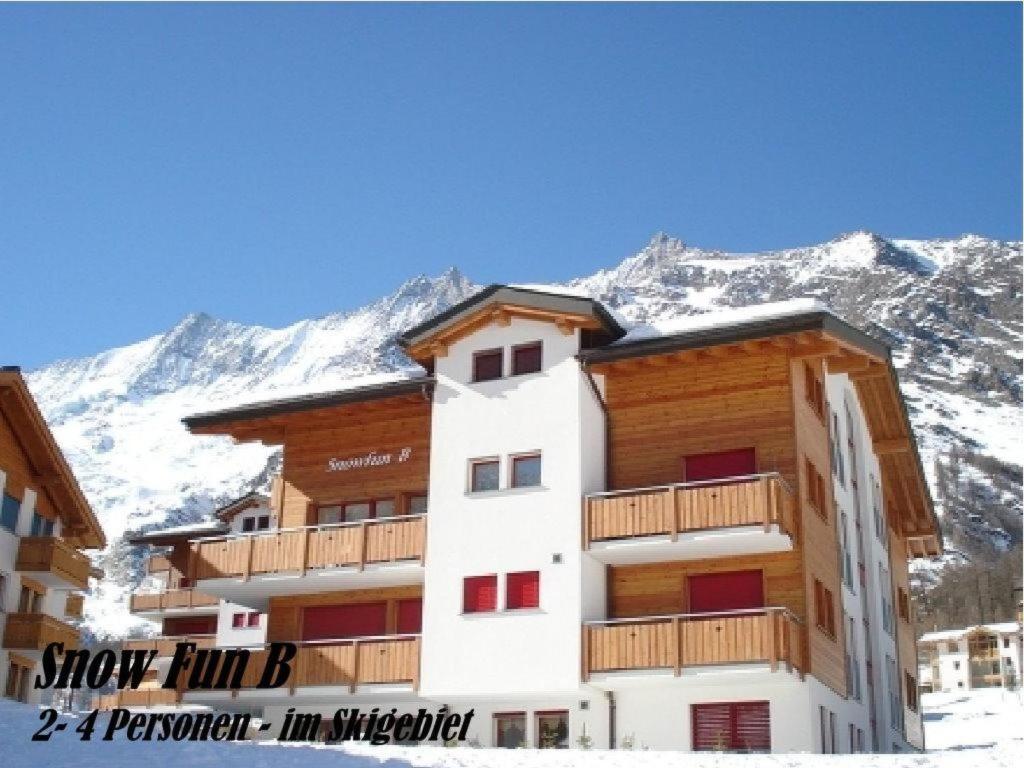 a building with snowy mountains in the background at Apartment Snow-Fun B by Interhome in Saas-Fee