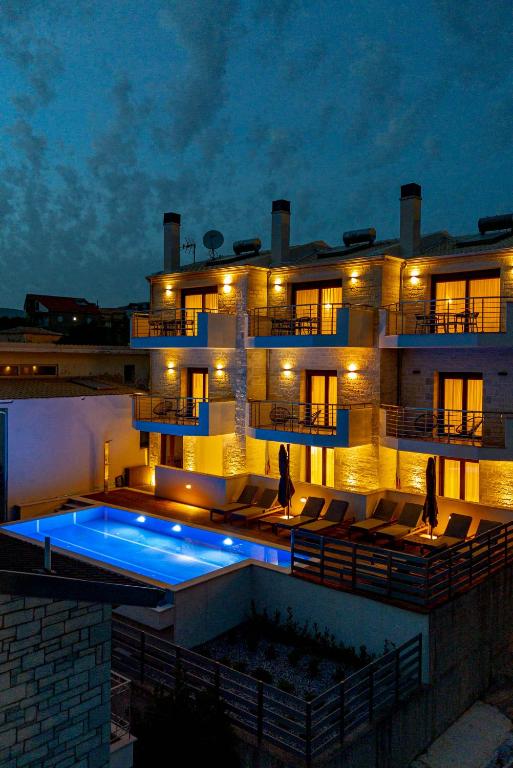 a building with a swimming pool in front of it at Perdika Ionion Villas in Perdika