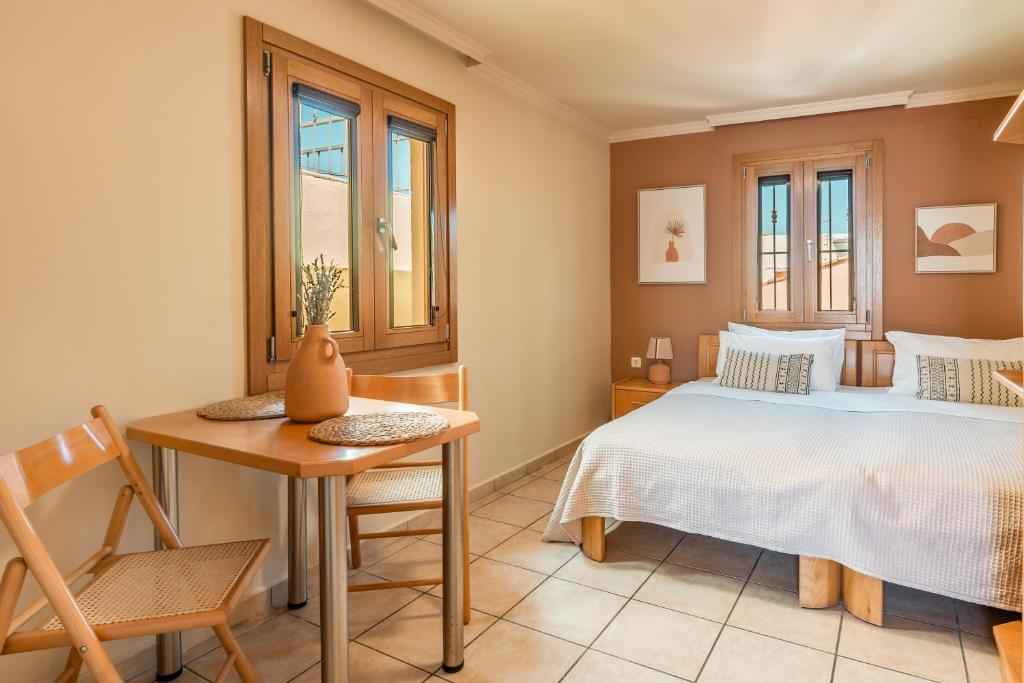 1 dormitorio con 1 cama, mesa y silla en Lidra Rooms, en La Canea