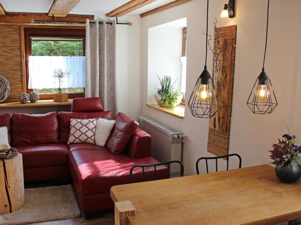 ein Wohnzimmer mit einem roten Sofa und einem Tisch in der Unterkunft Apartment Ehinger by Interhome in Eisenbach