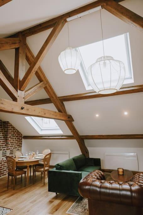 un salon avec un canapé vert et une table dans l'établissement Suite Léon - 2 pers, à Charleville-Mézières