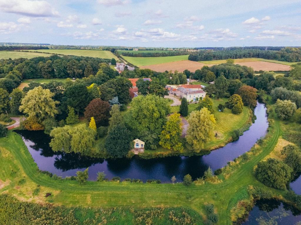 an aerial view of a house on an island in a river at West Lexham Manor in King's Lynn
