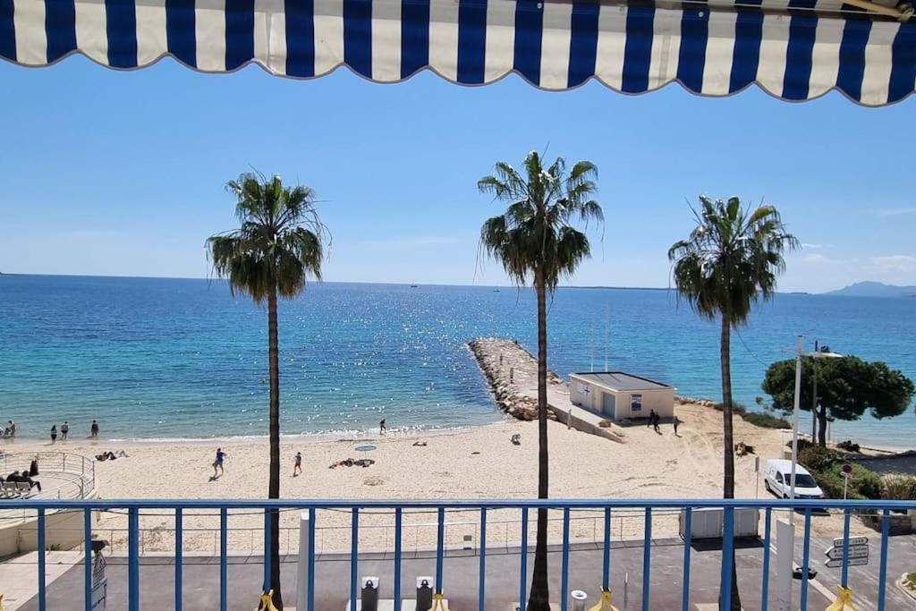 Una vista de una playa con palmeras y el océano. en Ravissant T1 au bord de l'eau Juan Les Pins, en Antibes