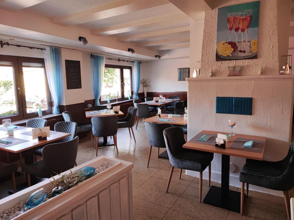 un restaurante con mesas y sillas en una habitación en Gasthaus "Zur frischen Quelle", en Laubach