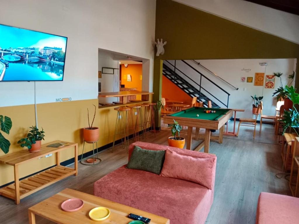 a living room with a couch and a pool table at La Seventy Nomad Mood in Medellín