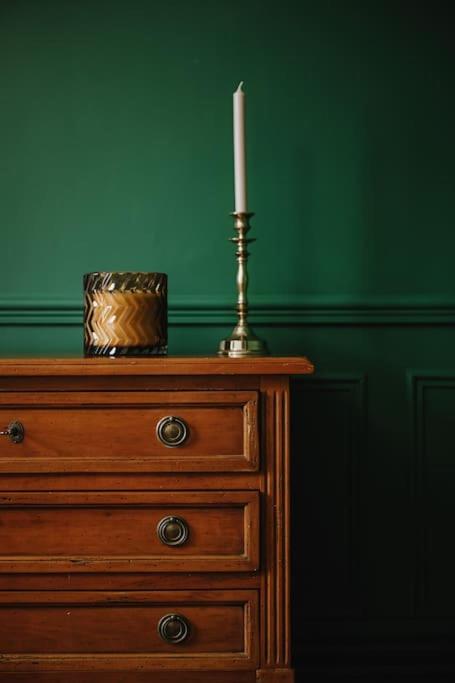 une bougie posée sur une commode avec une commode dans l'établissement Suite Ernest - 2 pers, à Charleville-Mézières