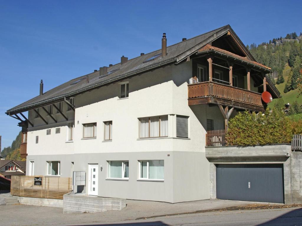 ein weißes Haus mit Balkon darüber in der Unterkunft Apartment Honegger by Interhome in Churwalden
