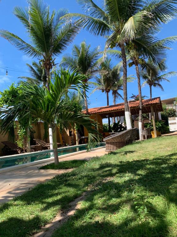 a house with palm trees in front of it at Ville Sweet Home in Canoa Quebrada
