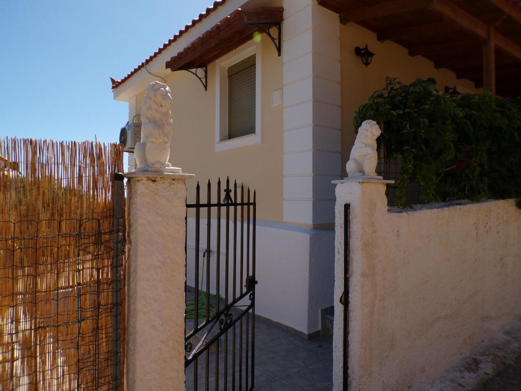 un portail en face d'une maison avec une clôture dans l'établissement Reggina's place, à Céphalonie