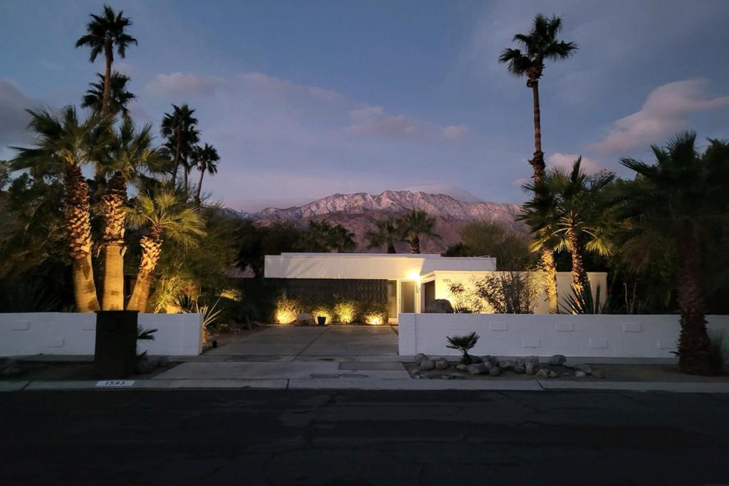 a building with palm trees and a mountain in the background at Tres Palmas Permit# 384 in Palm Springs