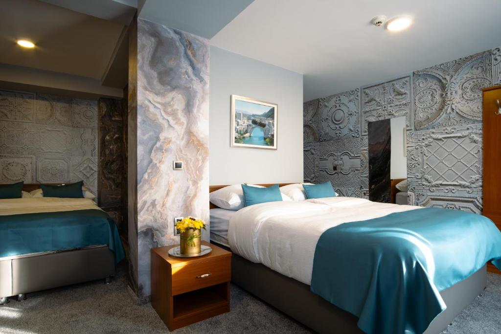 1 dormitorio con 2 camas y sábanas azules en Villa Harmony, en Sarajevo